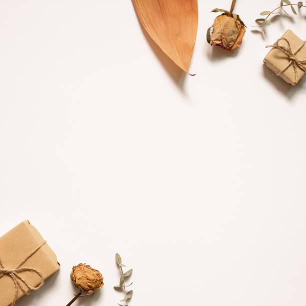 istock Gift boxes with autumn dry flowers on white background. flat lay, top view, copy space 1272104270