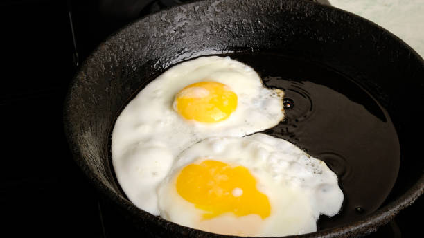 istock chicken eggs, fried eggs in a cast iron pan close-up, breakfast, omelet, two eggs with yellow yolks are fried on the stove 1272105073