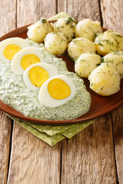 Traditional Frankfurter Gruene Sosse green sauce with boiled potatoes and eggs close-up in a plate. vertical