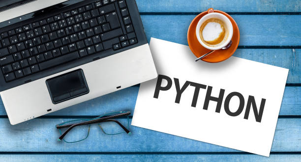 istock Paper width word Python and laptop, glasses and coffee on wooden table 1272108725