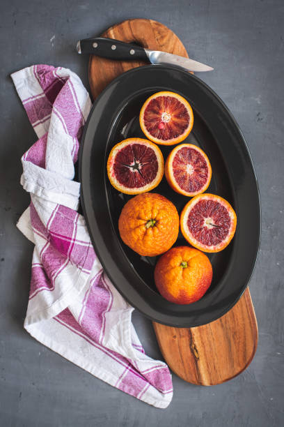 istock Fresh bloody oranges on a black plate on a dark gray background 1272115496