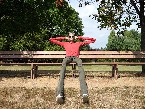 Adult stretching over a long park bench