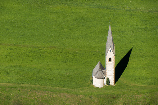 Idyllic little church in the heart of nature, scenic German Alps landscape in Berchtesgaden with mountains in the background, blue sky and lush trees