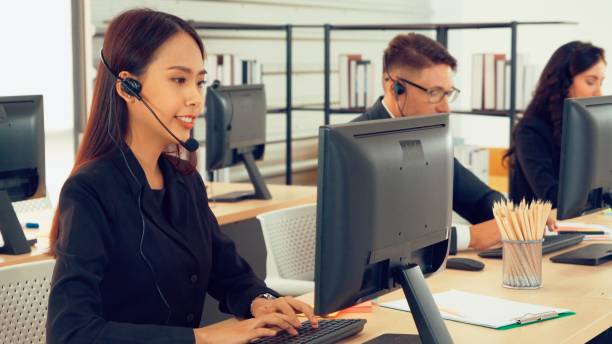 istock Business people wearing headset working in office 1272116015