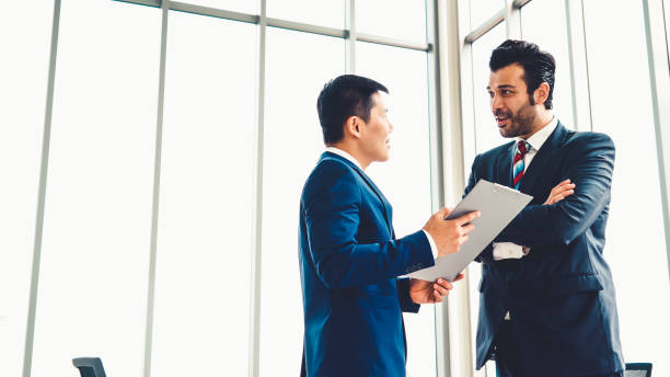 istock Two business people talk project strategy at office 1272116868