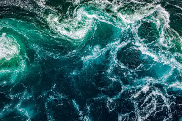 Abstract background. Waves of water of the river and the sea meet each other during high tide and low tide. Whirlpools of the maelstrom of Saltstraumen, Nordland, Norway