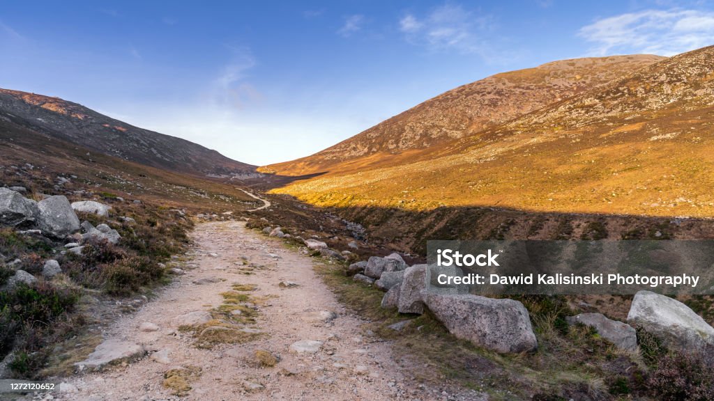 Winding trail in the valley between Slieve Donard and Rocky Mountain in Mourne Mountains Hiking on winding trail in the valley between Slieve Donard and Rocky Mountain in Mourne Mountains, County Down, Northern Ireland Dirt Road Stock Photo