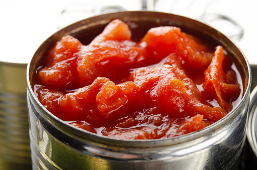 Canned sliced tomatoes in just opened tin can. Non-perishable food