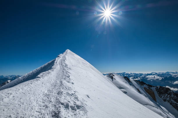 mont blanc (monte bianco) schneebedeckter 4808m gipfel weitwinkelansicht mit umgebender französischer alpenlandschaft mit tiefblauem himmel und strahlender mittagssonne. beliebte natur sehenswürdigkeiten konzept bild. - mont blanc ski slope european alps mountain range stock-fotos und bilder