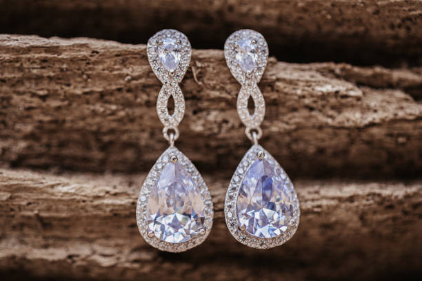 diamentowe kolczyki ślubne wiszące na drewnianym tle - diamond earrings zdjęcia i obrazy z banku zdjęć