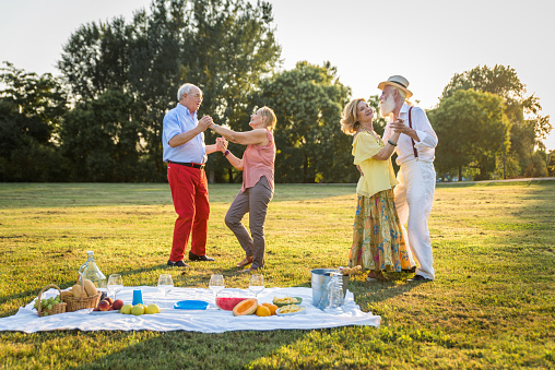 Group of youthful seniors having fun outdoors - Four pensioners bonding outdoors, concepts about lifestyle and elderly