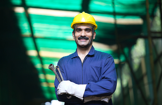 Confident industrial worker in protective work wear at factory