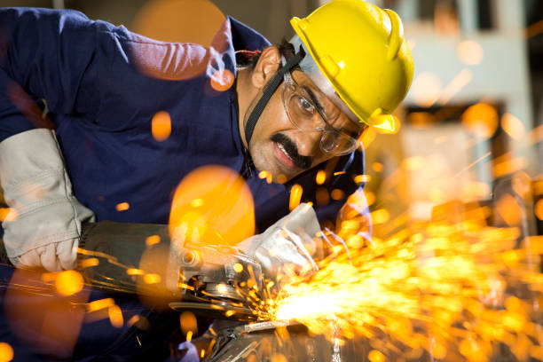 istock Mechanic using circular saw grinder tool with protective work wear at factory 1272134692