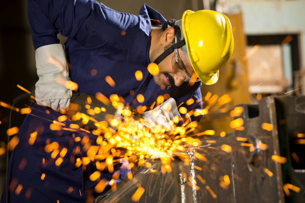 istock Mechanic using circular saw grinder tool with protective work wear at factory 1272134713