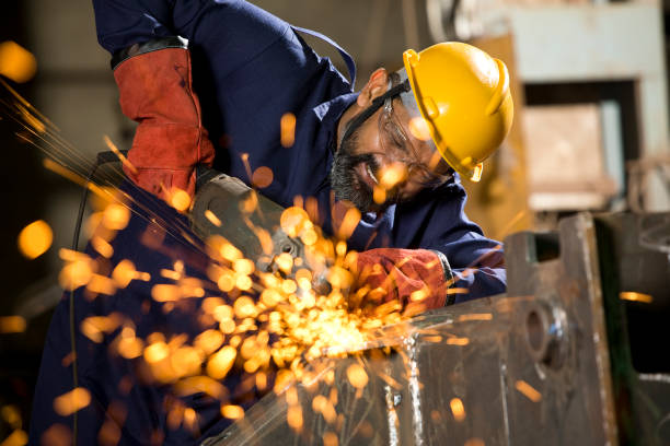 istock Mechanic using circular saw grinder tool with protective work wear at factory 1272134782