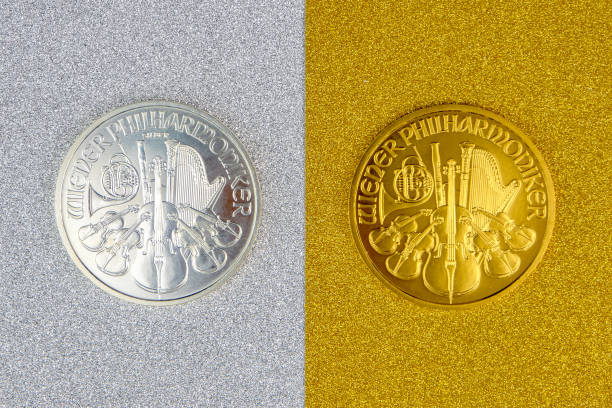 argent et or autrichien à la menthe phillharmoniker une once pièces de monnaie s’étendant sur l’argent et le fond d’or - joueur de champ gauche photos et images de collection