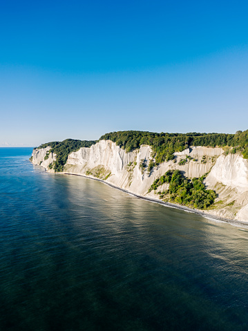 Drone’s eye view looking at cliffs at Moens Klint. Photographed in th early autumn on the island of Moen in Denmark. Colour, vertical format with some copy space .