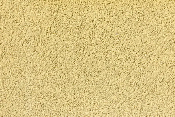 harmonic pattern of yellow painted plaster wall