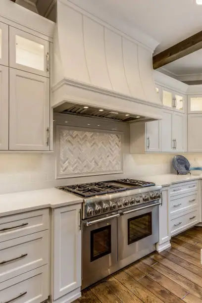 White kitchen with square tiles behind cooktop