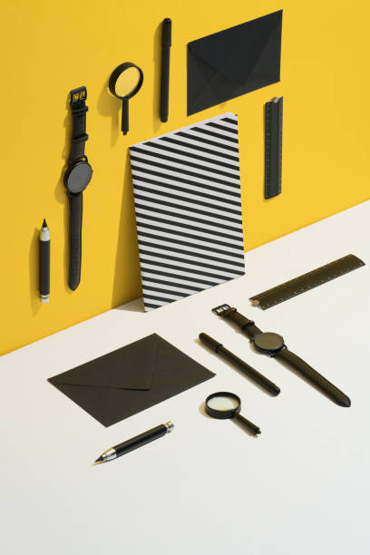 Black personal accessories, stationary flat lay with black and white stiped cover notebook on yellow and white background