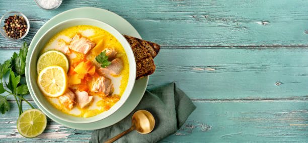 Fish soup with salmon on light turquoise blue wooden background