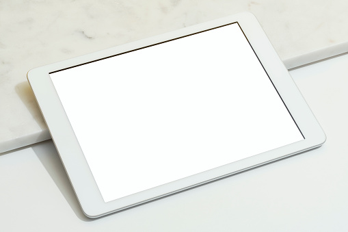 Blank white screen digital tablet mockup, template on white and marble background.