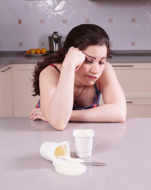 istock Indifferent young woman looking at a yoghurt spilt 1272151556