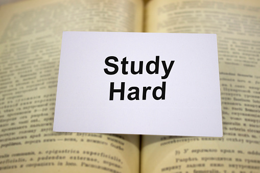 Study hard written in white note on open book