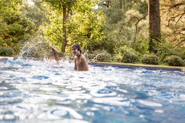 istock Teen jumping in pool 1272162438