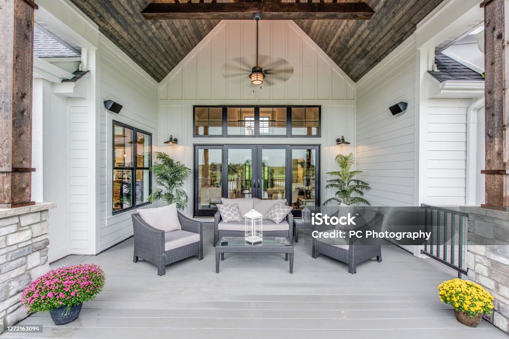 Gorgeous deck with comfortable seating to enjoy a lovely evening outside Wood panel vaulted covering on outdoor gathering area of new home Patio Stock Photo