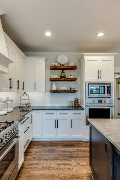 Floating shelves between white cabinetry in kitchen Beautiful counters with many modern amenities nearby recessed light stock pictures, royalty-free photos & images