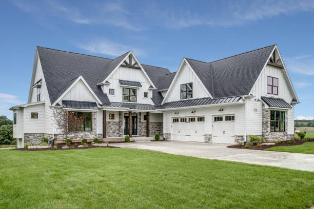 Large house with steep roof and side entry three car garage Beautiful design and detail on new home real estate stock pictures, royalty-free photos & images