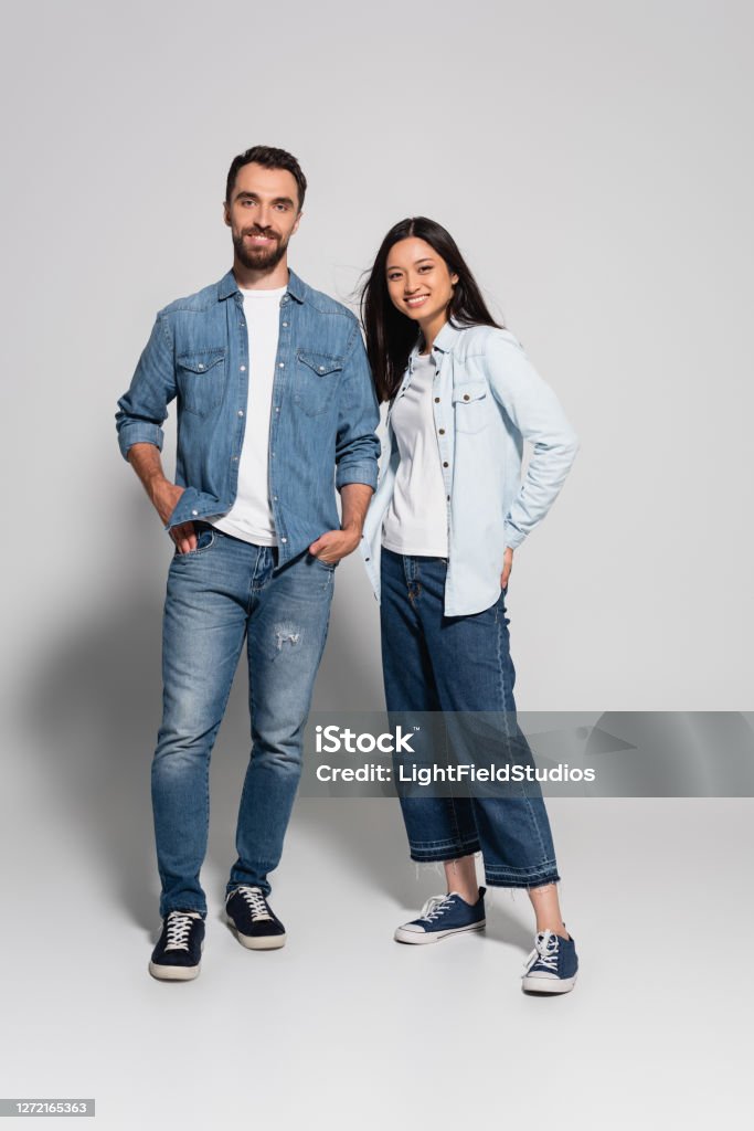 Vista De Longitud Completa De La Pareja Interracial Con Estilo En Jeans Y Camisas De Mezclilla Mirando A La Cámara En Blanco Foto de stock y más banco de imágenes de Parejas - Vista De Longitud Completa De La Pareja Interracial Con Estilo En Jeans Y Camisas De Mezclilla Mirando A La Cámara En Blanco Foto de stock y más banco de imágenes de Parejas -