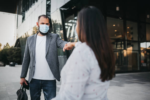 istock Business people with masks greeting with elbow bump 1272165481