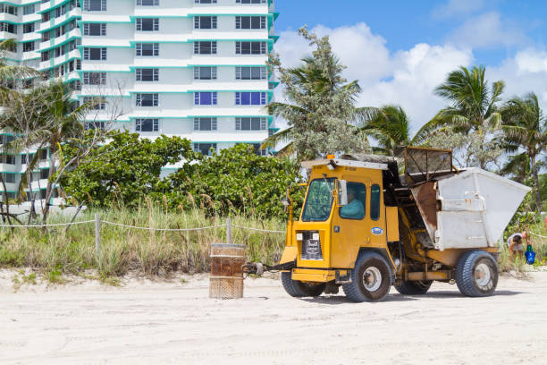 trattore che pulisce la spiaggia a miami beach, florida, usa - environmental conservation cleaning rubble recycling bin foto e immagini stock