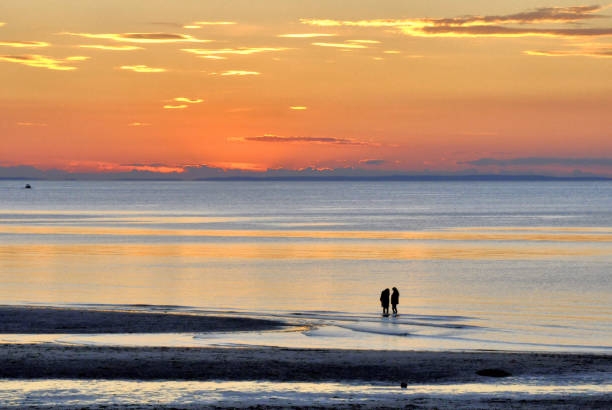 deux jeunes femmes à la plage appréciant le coucher du soleil - cape cod bay photos et images de collection