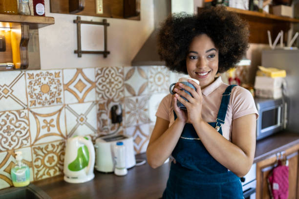 istock Relaxed young afro woman drinking coffee in the kitchen 1272168263