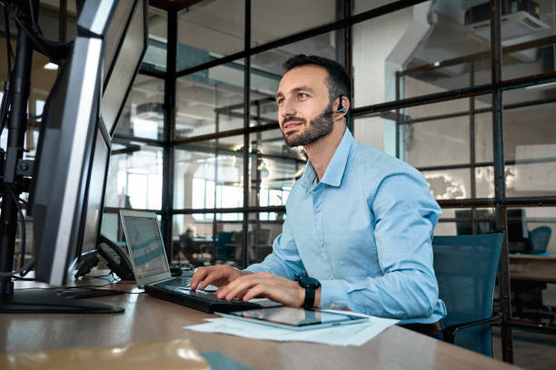 Stock broker with headset analyzing index on cryptocurrency diagram Confident stock broker wearing in headset looking at display, analyzing index on crypto currency market diagram, working in office, talking with client dispatcher stock pictures, royalty-free photos & images