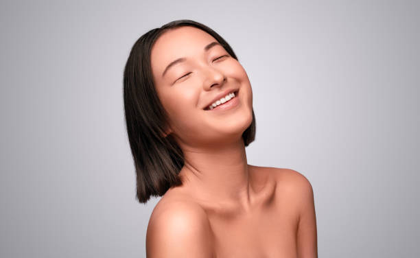 istock Optimistic Asian female model laughing with closed eyes 1272168732