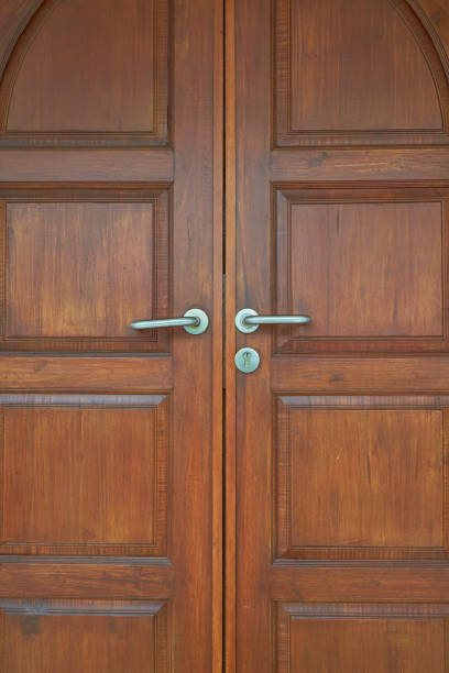 istock real old wood door with silver handle and key lock background 1272170621