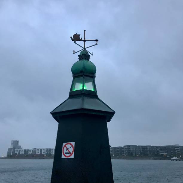 istock Green light in old lighthouse one rainy morning 1272180811