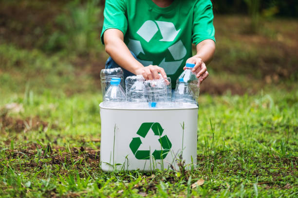 istock A woman collecting and putting plastic bottles into a recycle bin 1272184045