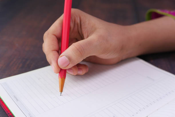 istock Close up of women hand writing on notepad. 1272188883
