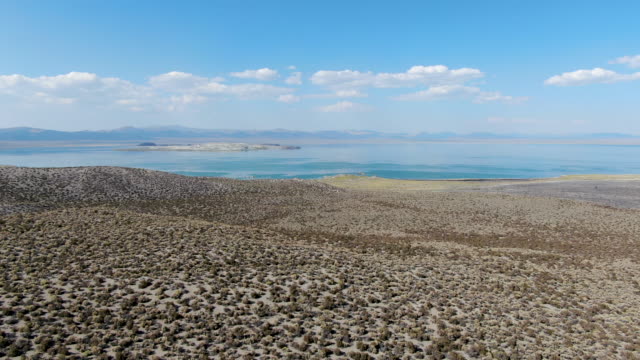 Aerial view of dusty dry desert land with Mono Lake on the background, Mono County