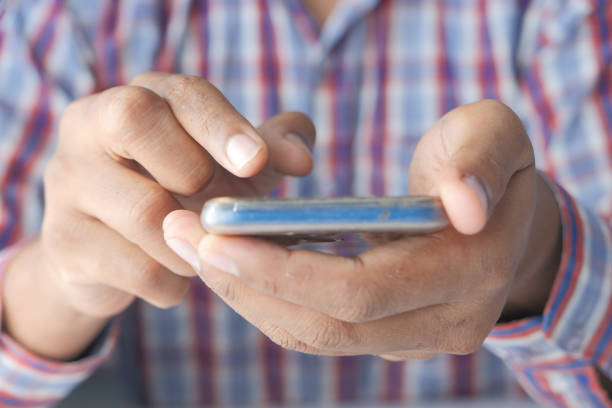 istock Close up of young man hand using smart phone. 1272189714
