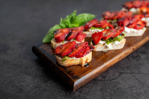 Bruschetta Sandwich with strawberries Bruschetta Sandwich with strawberries, soft goat cheese, basil and balsamic glaze, served as an appetizer bruschetta stock pictures, royalty-free photos & images