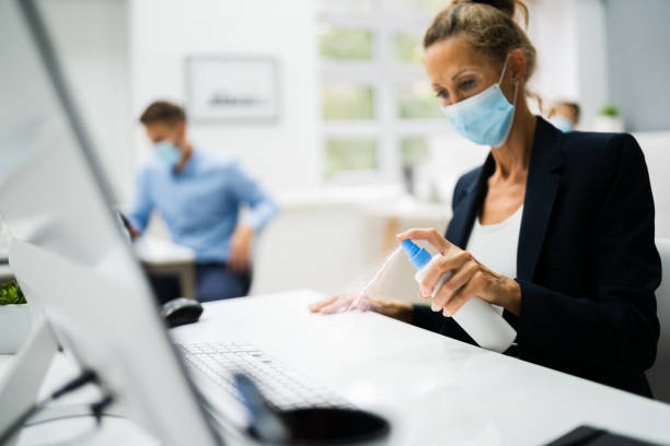 istock Woman Cleaning Desk In Office Using Disinfectant 1272197673