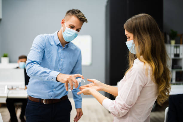 istock Cleaning Hands At Office Entrance Using Sanitizer 1272197706