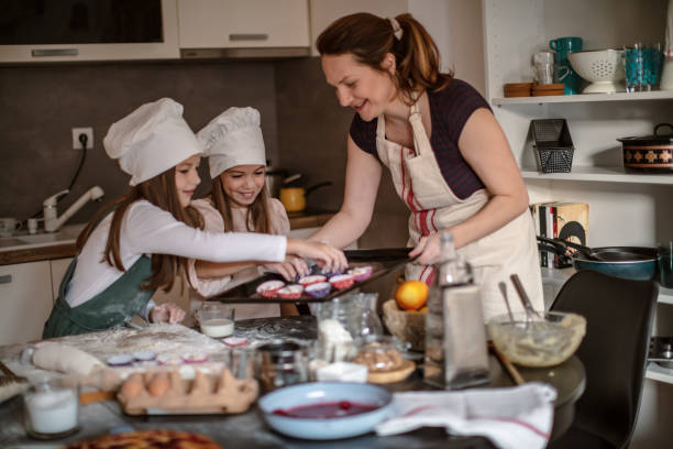 istock Mother and Girls making cookies 1272198722
