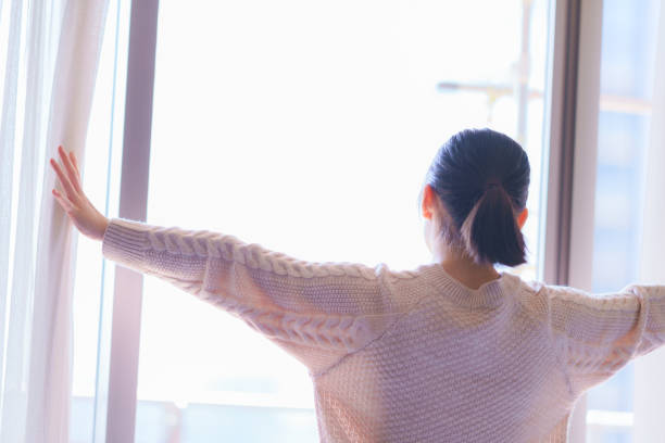 luce del sole del mattino - waking up window women morning foto e immagini stock